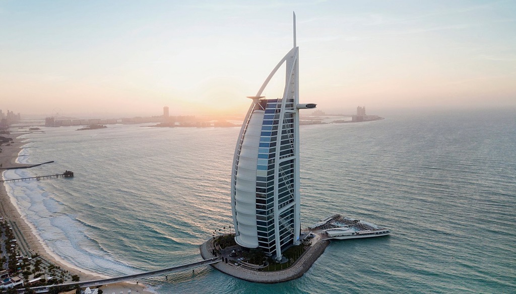 Luxurious sail-shaped Burj Al Arab hotel on its artificial island off Dubai’s coast at sunset.