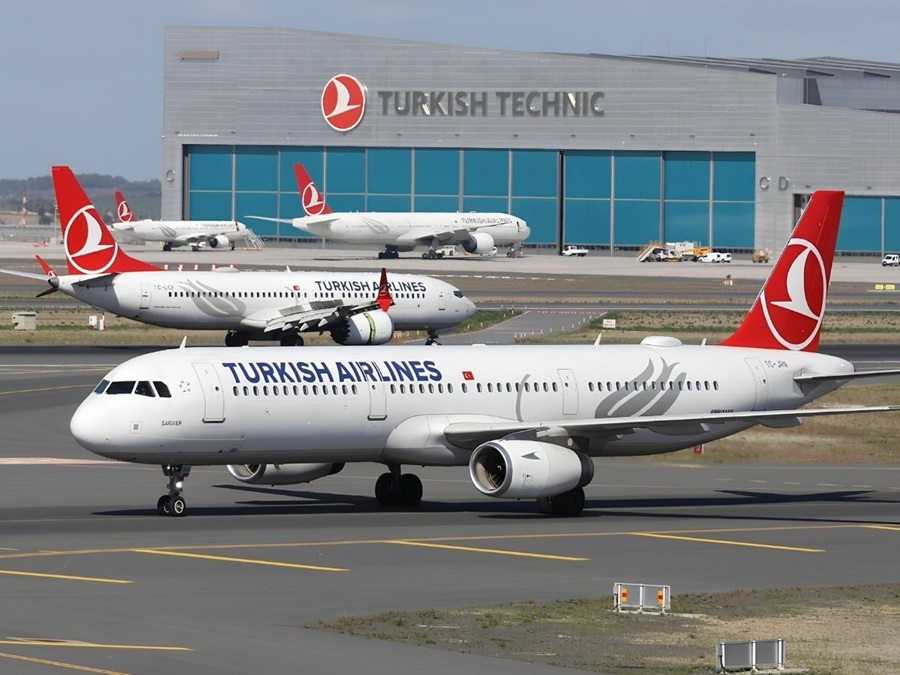 Turkish Airlines jet taxiing on runway with a large hangar labeled Turkish Technical in the background.