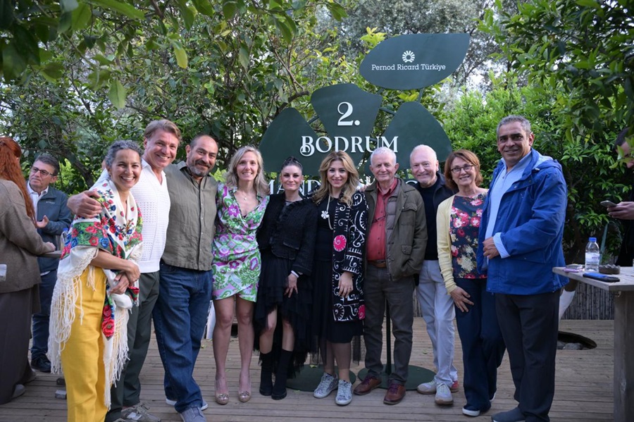 Twelve adults posing outdoors in front of a large Bodrum sign with Pernod Ricard Türkiye logo in a leafy setting.